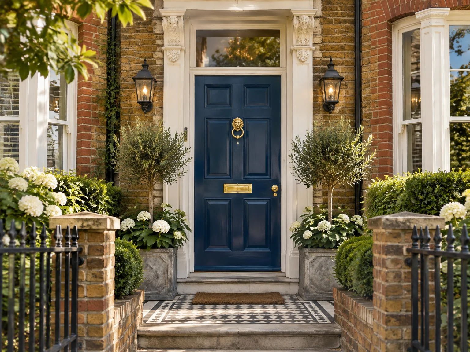 Complete petrol-blue front door of a British home with brass fittings and planting
